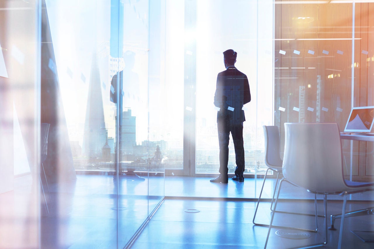 Businessman looking out of office over city